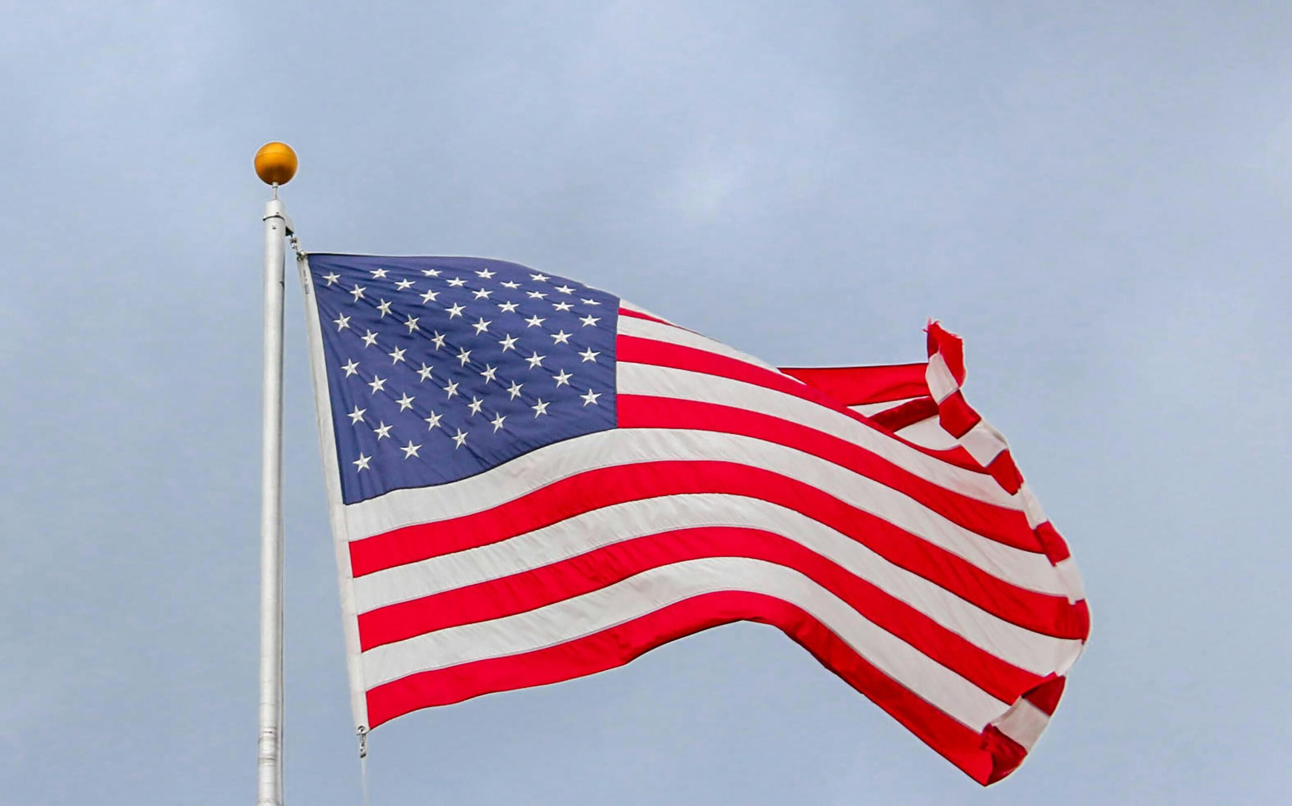 A vibrant image of the American flag waving proudly against a clear blue sky, symbolizing freedom.